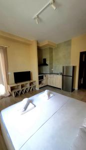 a kitchen with a large white bed in a room at Kron Apart Hotel Golem in Golem