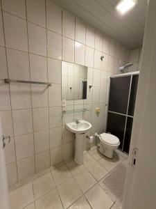 a bathroom with a toilet and a sink at Apto centro 03 in Tubarão +13 photos