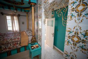 a small bedroom with a bed and a door at Milles et une Nuits Sidi Bou in Dar Salah Bey