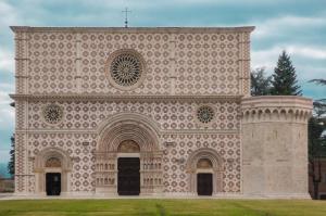 a large stone building with a cross on top at La Tana della Volpe in Tempera