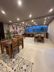 a dining room with tables and chairs and windows at Maple house ladakh in Leh