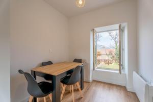 a dining room with a table and chairs and a window at Le Saphir By Clem in Pélussin +9 photos