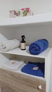 a white shelf with towels and a bottle on it at Departamento Salomé in Eduardo Castex +9 photos