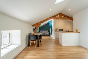 a kitchen and living room with a table and chairs at L'Emeraude By Clem in Pélussin +11 photos