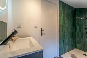a bathroom with a sink and a shower at L'Emeraude By Clem in Pélussin