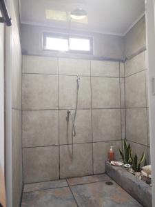a shower with a glass door in a bathroom at El Carao in Talamanca
