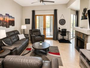 a living room with leather furniture and a fireplace at Lighted Pool Nights Fenced Yard & Mountain View in Tucson