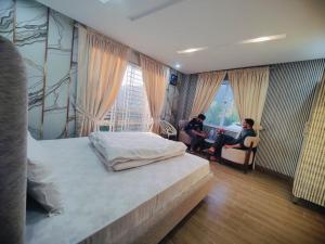 a bedroom with a bed and two people sitting at a desk at Snow Stones in Khaira Gali