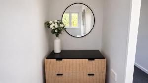 a table with a mirror and a vase with flowers at Bayview at the Port in Port Bannatyne +4 photos