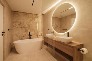 a bathroom with two sinks and a large mirror at Nono Ban Boutique Hotel & Villas in Gornji Humac