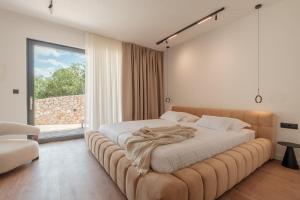 a bedroom with a large bed with a large window at Nono Ban Boutique Hotel & Villas in Gornji Humac