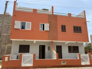 a orange and white house in front of a building at Lica in Espargos