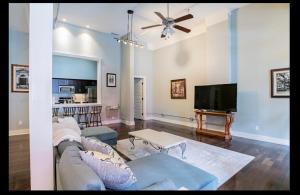a living room with a couch and a flat screen tv at Downtown Mobile Gem Steps from Cruise & Train Terminals in Mobile