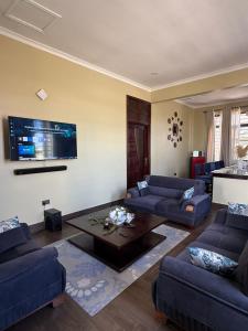 a living room with two couches and a coffee table at Nady Apartment in Dodoma
