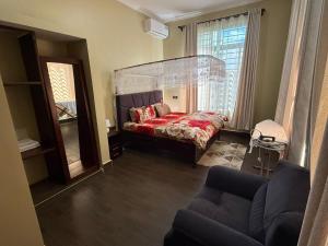 a bedroom with a bed with a large glass headboard at Nady Apartment in Dodoma