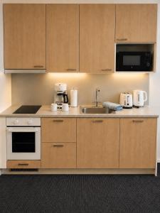 a kitchen with wooden cabinets and a sink at Finstay Turku in Turku