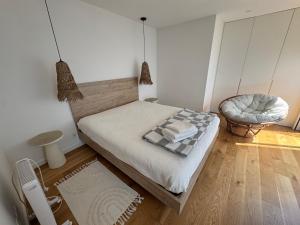 a small bedroom with a bed and a chair at Sea Breeze - Espinho Beach in Espinho