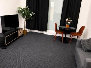 a living room with a couch and a tv and a table at Finstay Turku in Turku +5 photos