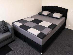 a bed with a black and white checkered blanket and a couch at Finstay Turku in Turku