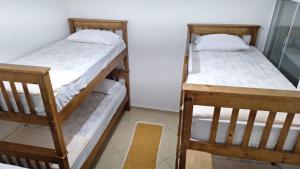 two bunk beds in a room with a yellow rug at Lírio-da-paz in Cachoeira Paulista
