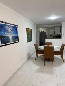 a living room with a table and chairs and a kitchen at Solar Areia Preta 302 in Natal