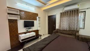 a living room with a couch and a flat screen tv at Shree Vaishnav Yatri Grah Near Mahakaleshwar Temple in Ujjain