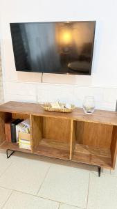 a flat screen tv on top of a wooden coffee table at Studio Jael Rivera in San Antonio +1 photo