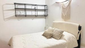 a bedroom with a bed and a shelf on the wall at Studio Jael Rivera in San Antonio