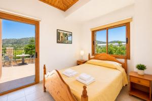 a bedroom with a large bed and a balcony at Villa Chrisandria in Argaka +23 photos
