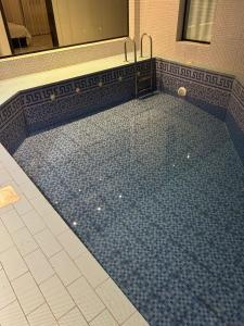 a swimming pool in a bathroom with blue tiles at شاليهات موج لاند 1 in Taif