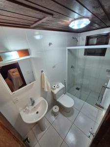 a bathroom with a toilet and a sink and a shower at Aratinga Inn in Abraão +88 photos