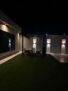 a room with two chairs and a table at night at شاليهات موج لاند 1 in Taif