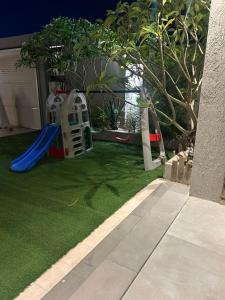 a small yard with a playground with a slide at شاليهات موج لاند 1 in Taif
