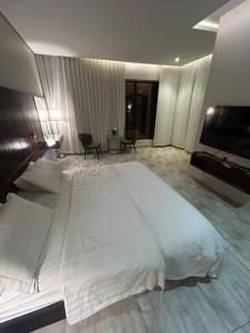 a large white bed in a hotel room at شاليهات موج لاند 1 in Taif