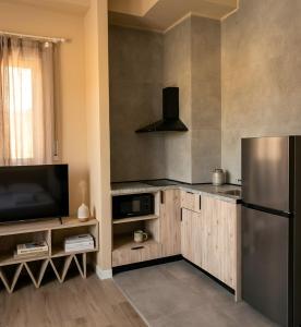 a kitchen with a refrigerator and a television at Kron Apart Hotel Golem in Golem