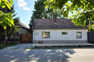 a white house with a black roof at Arany Virág Vendégház in Mór
