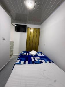 a small bedroom with a bed in a room at Hostal Ruta Cafetera in La Tebaida