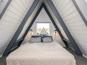 a bedroom with a bed in a attic at Himmerland Stay, Golf & Spa in Farsø +21 photos