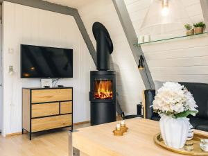 a living room with a fireplace and a tv at Himmerland Stay, Golf & Spa in Farsø