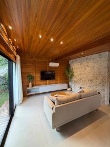 a living room with a couch and a tv at Chalé das Pedras - Domingos Martins in Domingos Martins