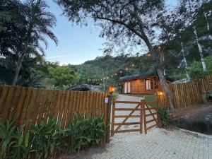 a house with a wooden fence and a gate at Chalé das Pedras - Domingos Martins in Domingos Martins