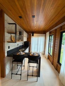 a kitchen with a table and chairs in a room at Chalé das Pedras - Domingos Martins in Domingos Martins