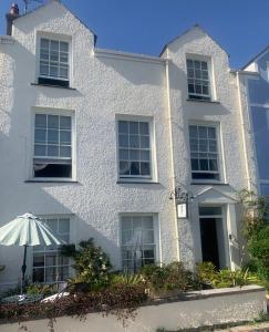 a white house with an umbrella in front of it at The Suites At Ty Anne in Beaumaris