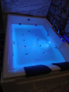 a jacuzzi tub with a blue light in a room at Suite San Giovanni in Gela
