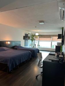 a bedroom with two beds and a desk with a computer at MySuites in Montevideo +37 photos