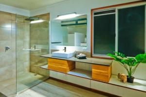 a bathroom with a sink and a mirror and a shower at Wine Down in Agnes Water