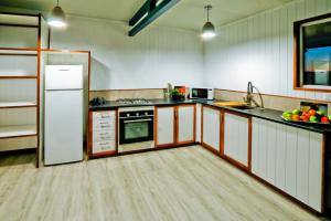 a kitchen with white cabinets and a white refrigerator at Wine Down in Agnes Water