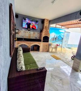 a living room with a fireplace and a flat screen tv at Casa no centro de Guapimirim, ar condicionado, piscina, churrasqueira, tranquilidade in Guapimirim