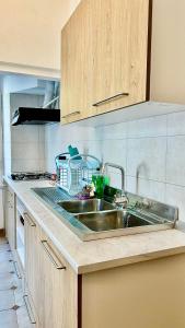 a kitchen with a stainless steel sink and wooden cabinets at Casa Garzoglio in Noli