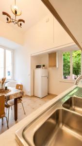 a kitchen with a sink and a table and a refrigerator at Casa Garzoglio in Noli +28 photos